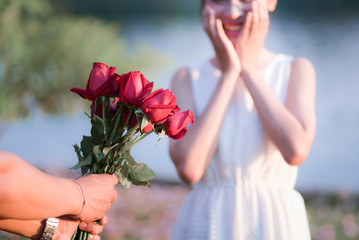 The young man gives a rose to a girl.