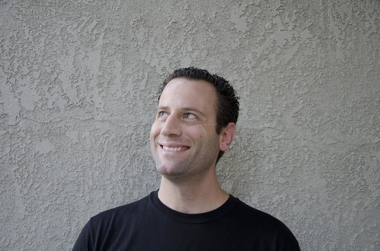 Man curiously looking up to the side with a smile.