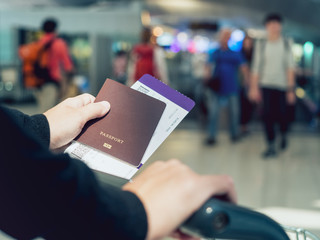 Hand holding Passport boarding pass ticket Blurred people Travel concept