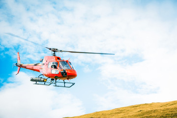 Fototapeta na wymiar Red Helicopter In The Swiss Alps
