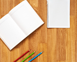 Blank notepad with office supplies on wooden table. Above view.