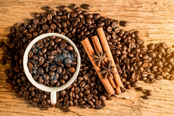 white cup of coffee and coffee bean on wood texture,top view