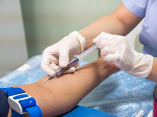 nurse with syringe is taking blood for test at the laboratory