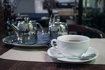 Obraz na płótnie Canvas Teapot and cup of tea in cafe