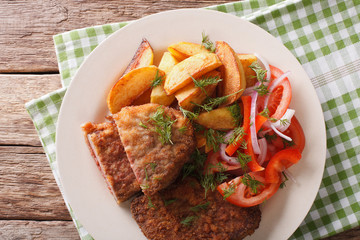 Fried rump steak and fresh vegetables, baked potatoes closeup. Horizontal top view