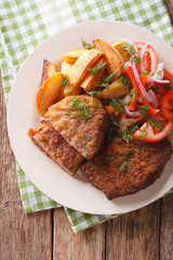 Fried rump steak and fresh vegetables, baked potatoes close up. vertical top view