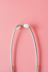 Stethoscope on pink background.