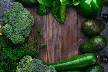 Food background of green vegetables broccoli romaine lettuce celery pepper zucchini on old brown wooden table Healthy lifestyle Top view Copy space
