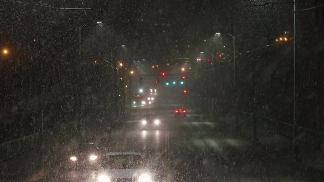 City Commuter Cars Driving in Dangerous Bad Weather at Night with Heavy Snowfall