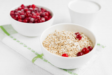 Rolled oats, porridge and cranberries for a healthy breakfast in a rustic style