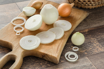 White onions on the wooden board in the kitchen. Healthy eating and lifestyle.