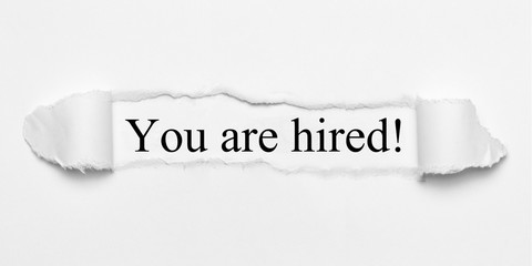 You are hired! on white torn paper