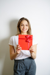 Smiling happy girl holding a red box. Concept gift on holiday