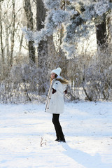 Obraz premium Woman in winter forest standing sideways to the camera