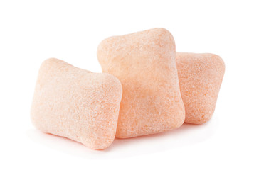 Peach color chewing gum piece on white