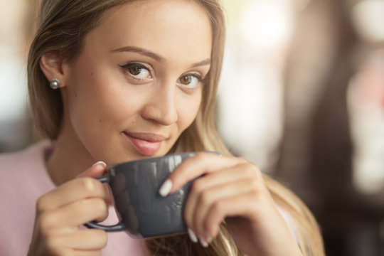 Woman Drinking Cup Of Tea In A Cafe - Closeup