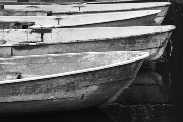 Old grungy rowboats moored in a row