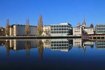 Colorful trees and buildings mirroring in the river Rhine