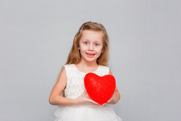 Pretty girl with long hair holding a heart. Valentine's day holiday