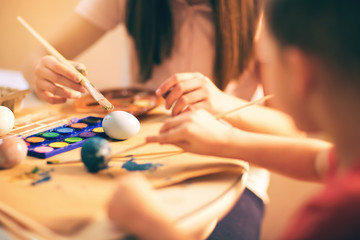 Brother and sister painted Easter eggs at the table