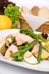 Fototapeta na wymiar Salmon salad with asparagus on a white plate with fresh herbs