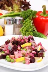 Beetroot salad with herring with a spicy sauce with spices on the white plate