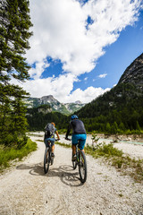 Mountain biking couple with bikes on track, Cortina d'Ampezzo, D