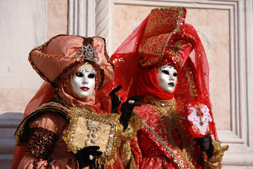 Fototapeta na wymiar Women in colorful costumes and masks posing at the Venice carnival in Italy