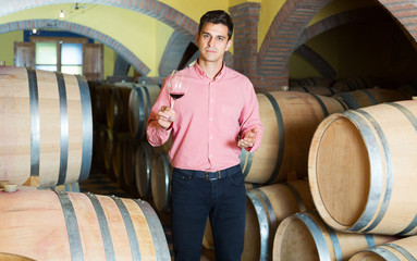 Man posing in winery cellar