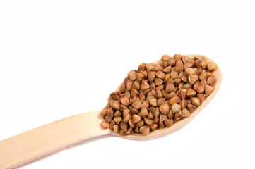 Uncooked buckwheat on wooden spoon. premium buckwheat groats on white background