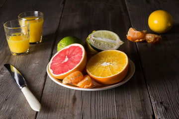 various types of citrus fruit on a dark wooden background