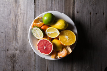 various types of citrus fruit on a dark wooden background