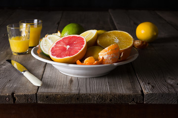 various types of citrus fruit on a dark wooden background