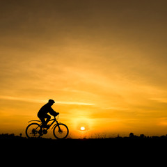 Obraz na płótnie Canvas Silhouette of cycling on sunset background.