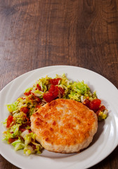 chicken burger with vegetables salad on plate. on wooden table with copy space. top view
