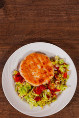 chicken burger with vegetables salad on plate. on wooden table with copy space. top view