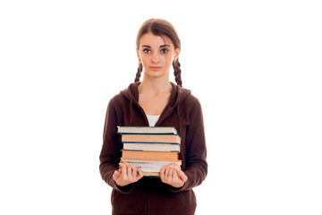 portrait of young attractive student girl in brown sport clothes with a lot of books in hands isolated on white background