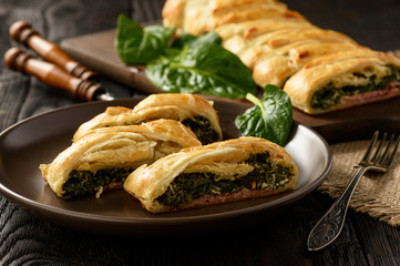 Homemade puff pastry pie with spinach, ham and cheese.