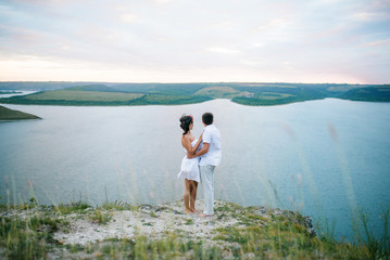 Loved couple in love at amazing landscape against cliff rocks.