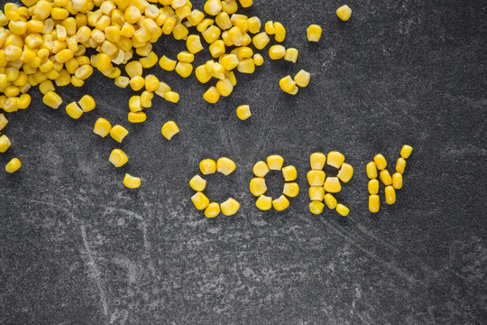 Word created from corn. Canned corn on the table in the kitchen. Healthy eating and lifestyle.