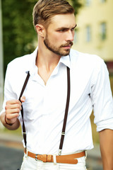 Fototapeta premium Handsome hipster model man in stylish summer clothes posing on street background