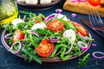 fresh green salad with arugula, tomatoes, mozzarella and red onion