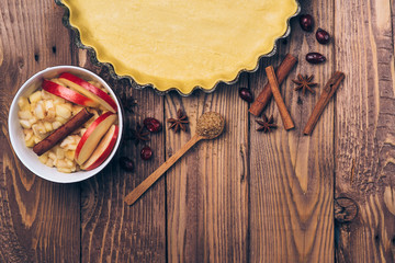 Ingredients for apple tart, apples and cinnamon on rustic wooden background.