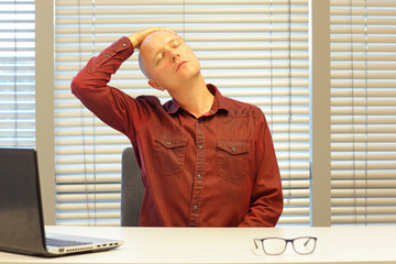 middle age balding man relaxing neck - short break for exercise on chair in office