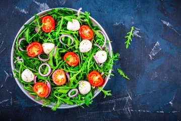 fresh green salad with arugula, tomatoes, mozzarella and red onion