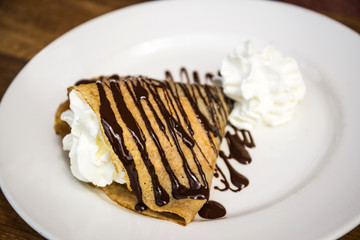 Delicious crepe with cream and chocolate dessert