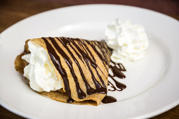 Delicious crepe with cream and chocolate dessert