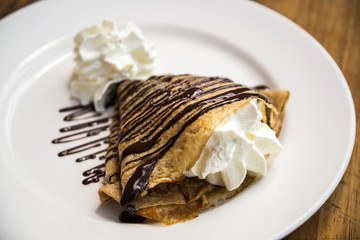 Delicious crepe with cream and chocolate dessert