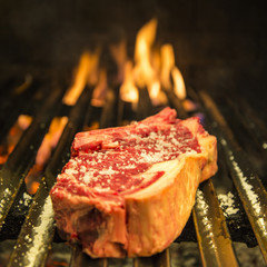 Cooking t-bone grilled steak in the barbecue