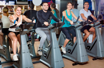 Group positive working out of cycling in fitness club